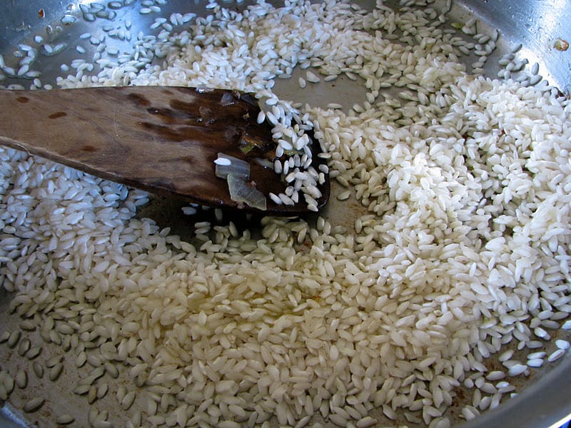 stirring the rice with a wooden spatula