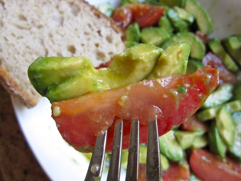 avocado and tomato salad on a fork