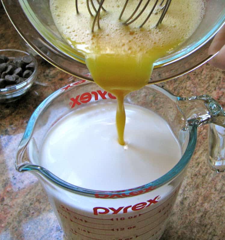 pouring beaten eggs into milk