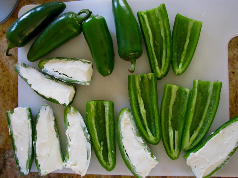 overhead shot of whole and sliced Jalapenos, some filled with cream cheese