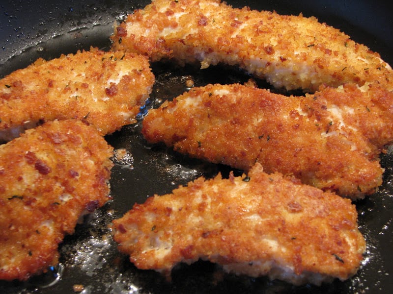 frying the chicken tenders in a pan