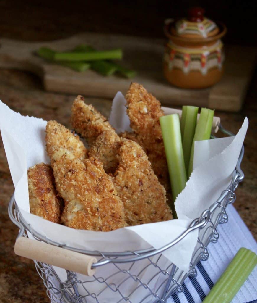 Homemade Breaded Chicken Tenders in a basket with celery