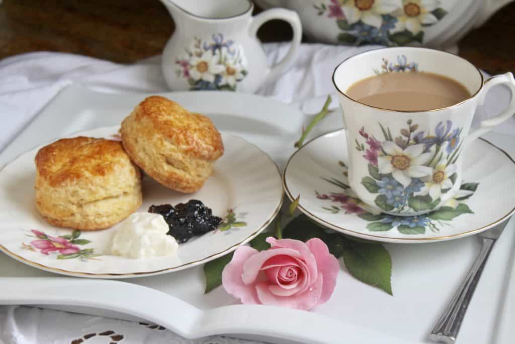 afternoon tea scones with cup of tea and a pink rose on a tray
