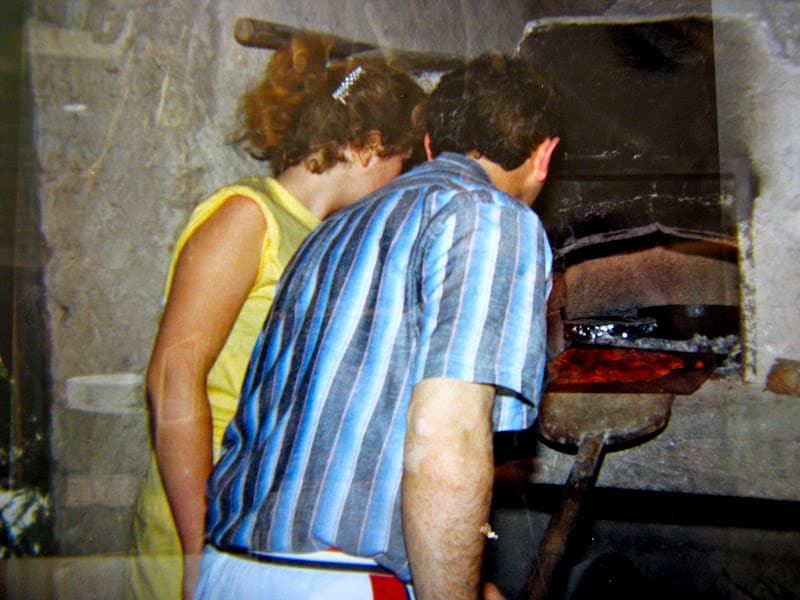 Christina and Gianfranco making pizza in a wood-burning oven in Italy