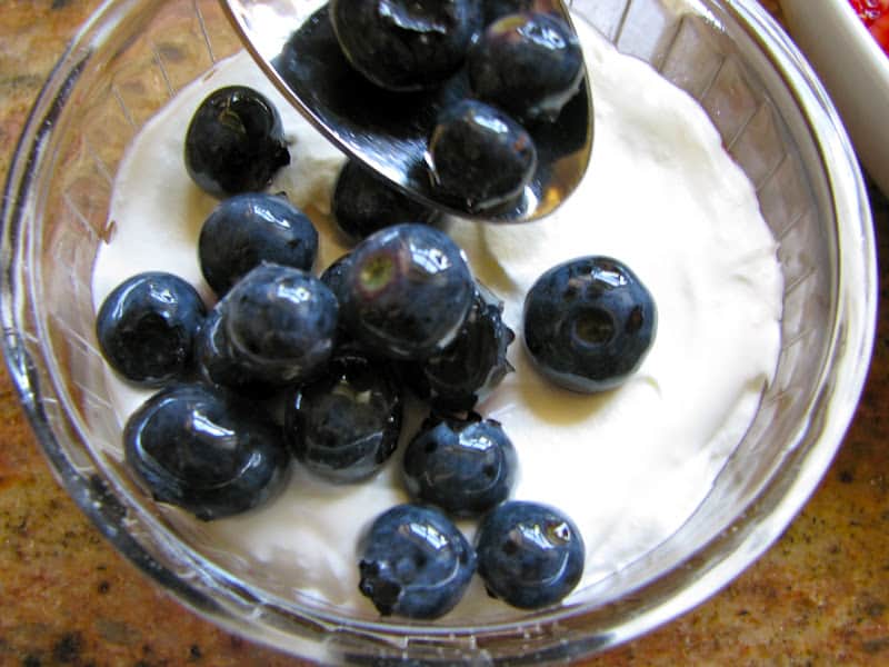 adding blueberries to cream