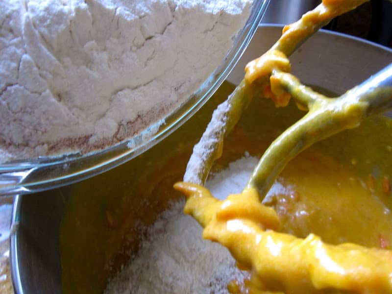 beater with batter and dry ingredients being added