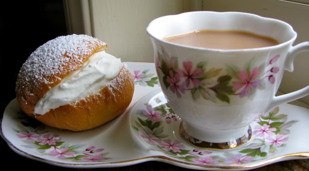 cream bun with cup of tea