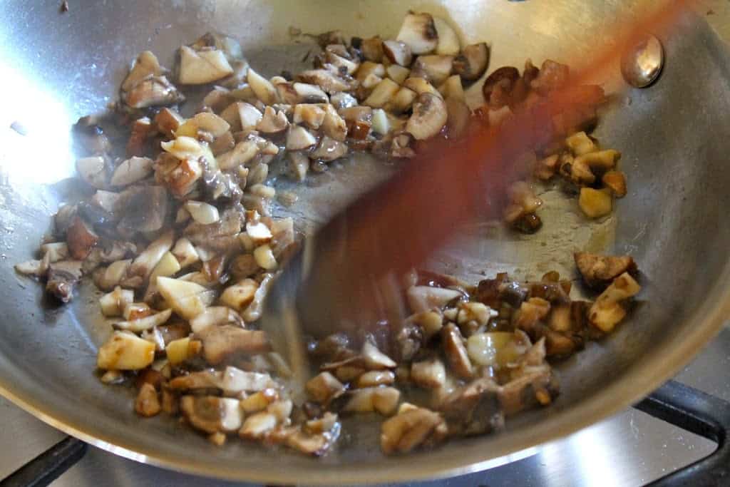 sauteeing mushrooms in a pan