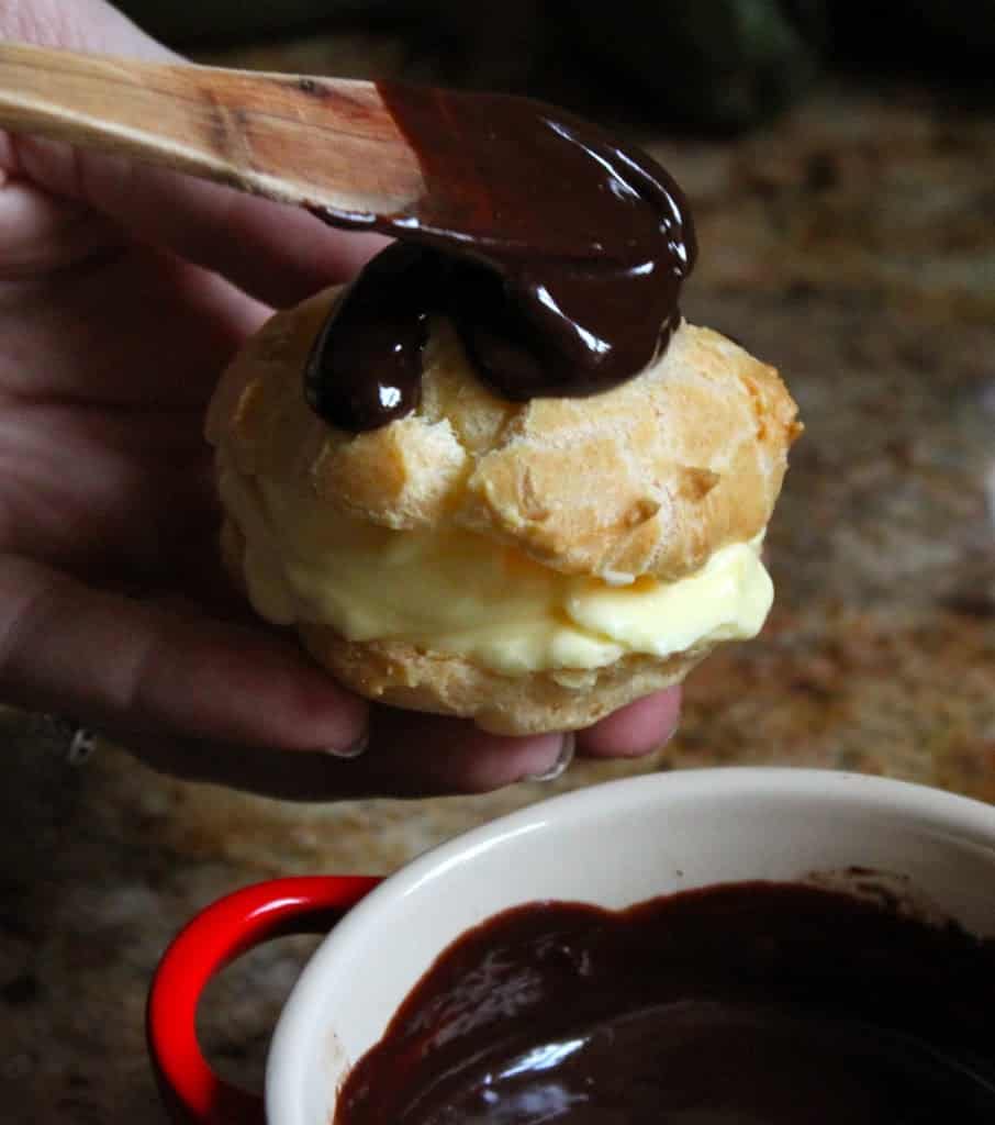 cream puff being slathered in chocolate