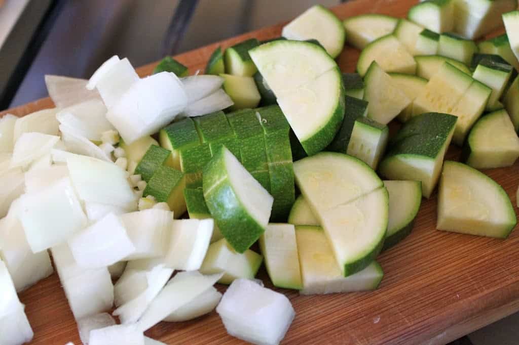 chopped onion and zucchini on a board