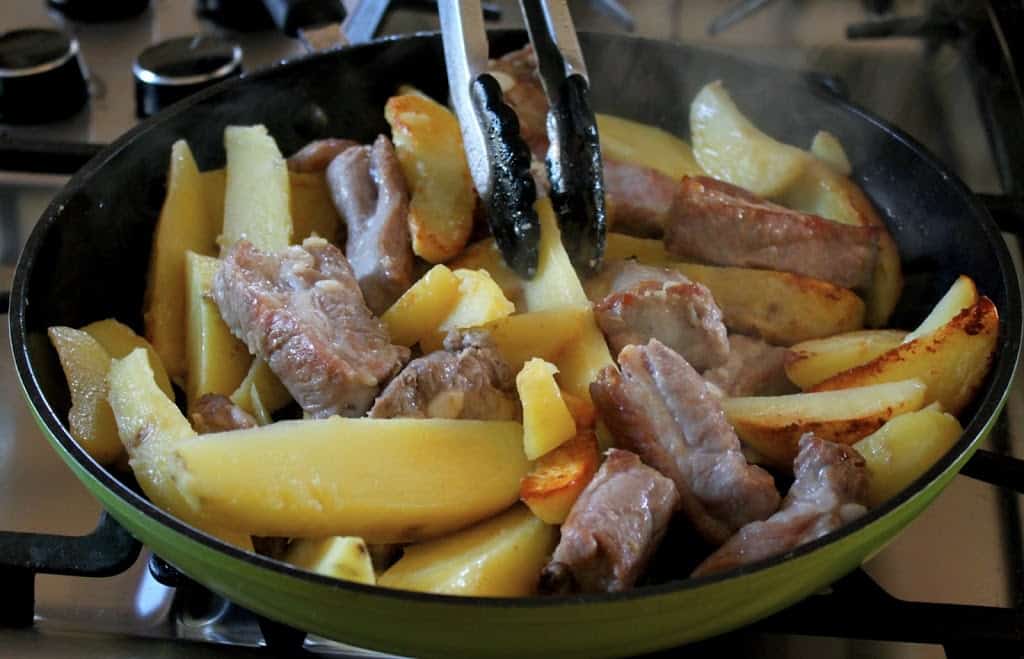 pork and potatoes in a frying pan