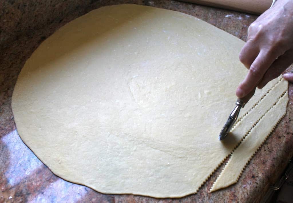 cutting strips of dough for chiacchiere
