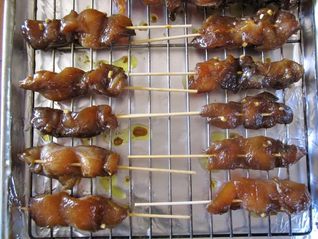 raw chicken satay skewers on a tray ready to cook
