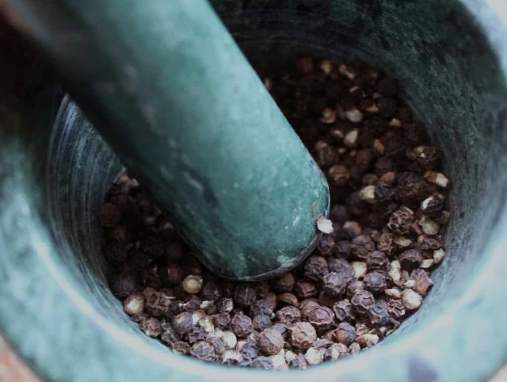 crushing peppercorns with a mortar and pestle