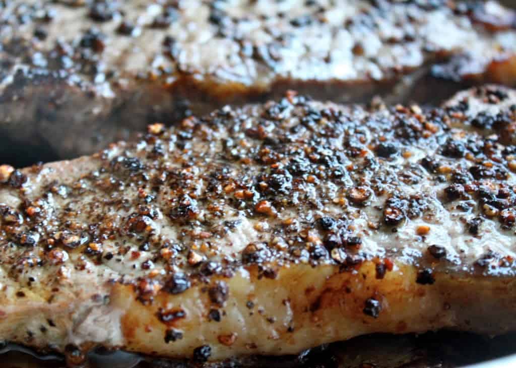 Steak au Poivre (Peppered Steak) sizzling in a pan