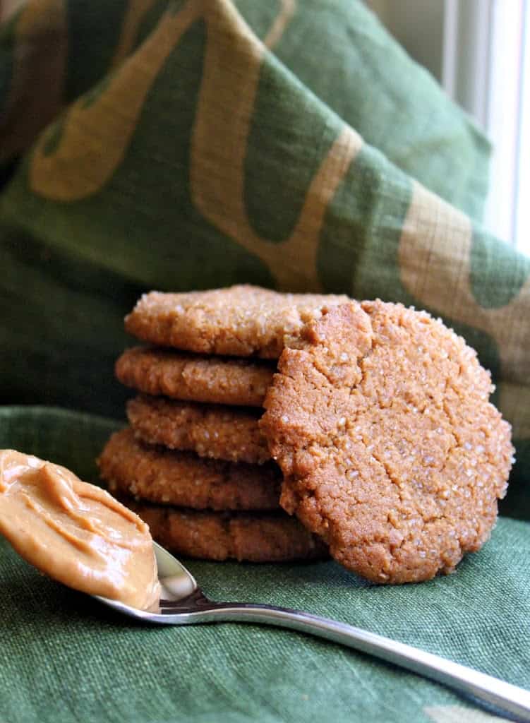 Gluten free peanut butter cookies piled up with a spoon of peanut butter