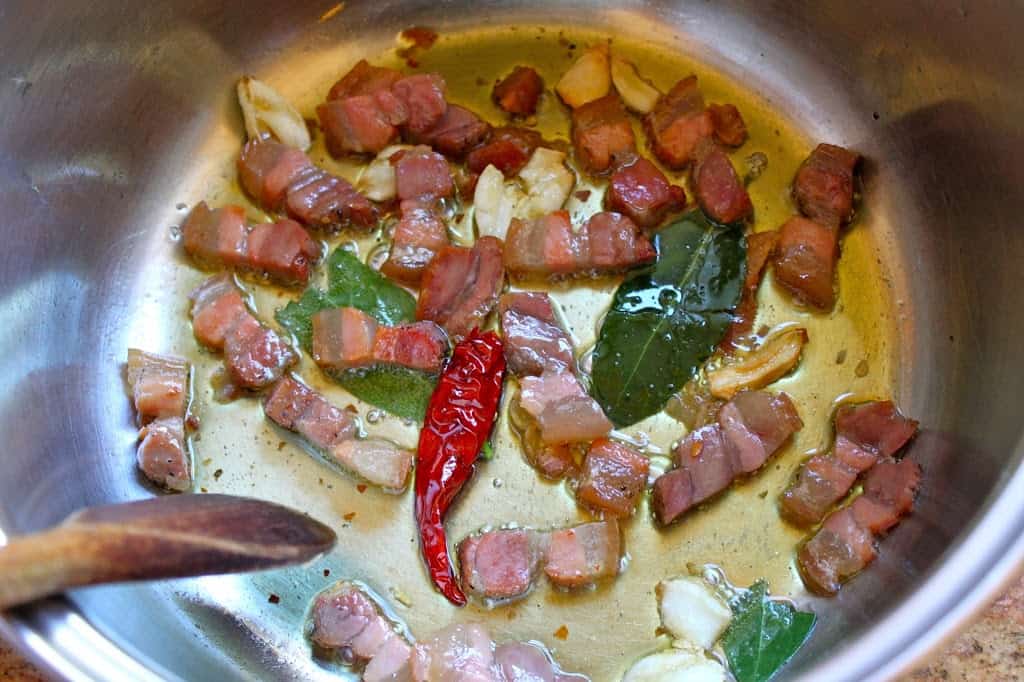 frying pancetta, bay leaf, hot pepper and garlic in oil