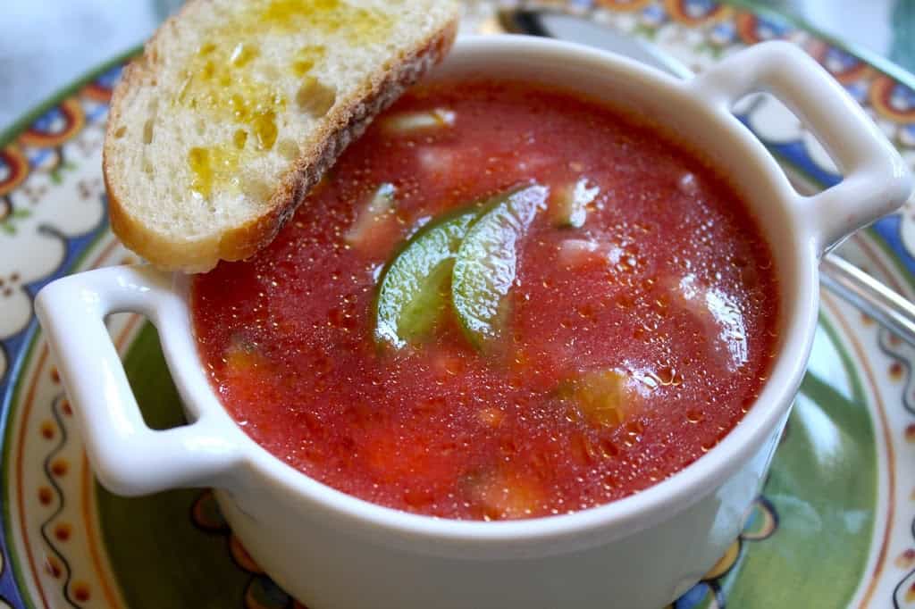 gazpacho in a bowl with oiled toast on the rim