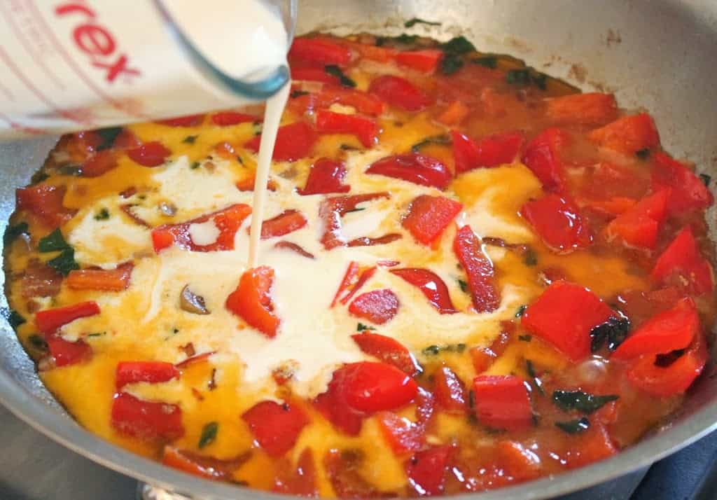 adding cream to red pepper mixture in pan