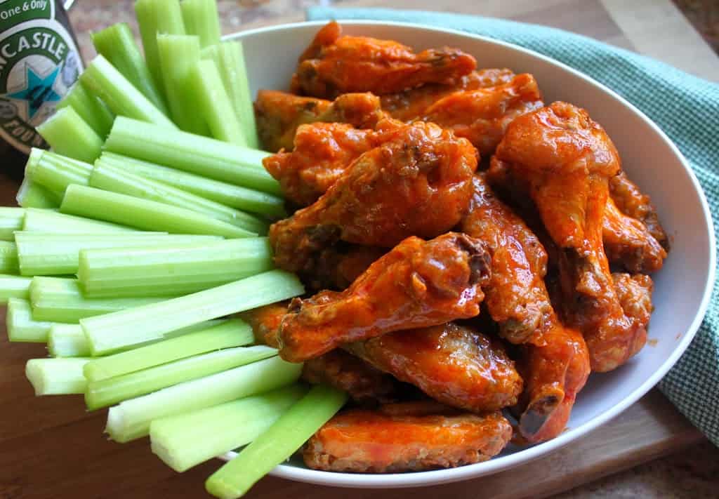 homemade buffalo wings or hot wings in a bowl with celery