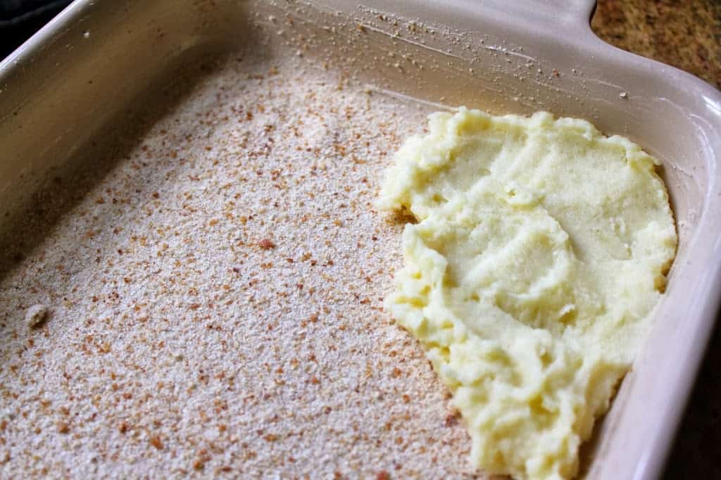 spreading mashed potato in tray