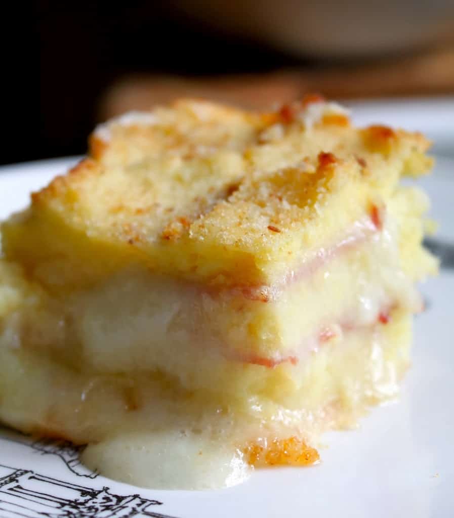 piece of cheesy potato casserole with ham on a plate