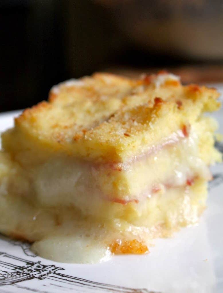 piece of cheesy potato casserole with ham on a plate