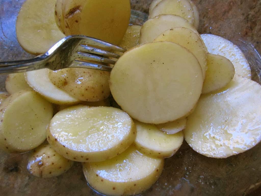 tossing potatoes with oil
