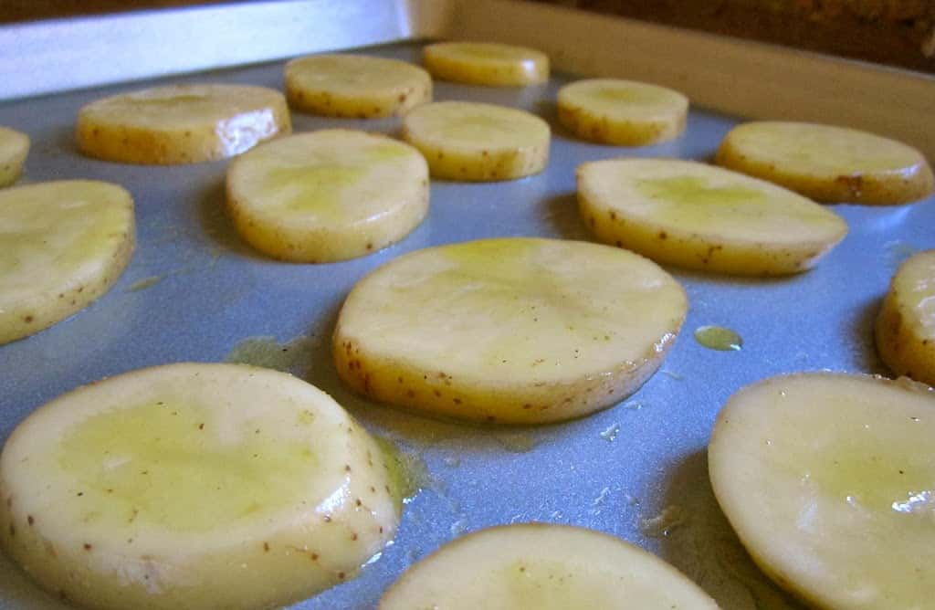 slices of potato and oil on a tray