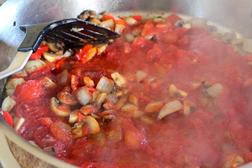 adding tomato puree to pan