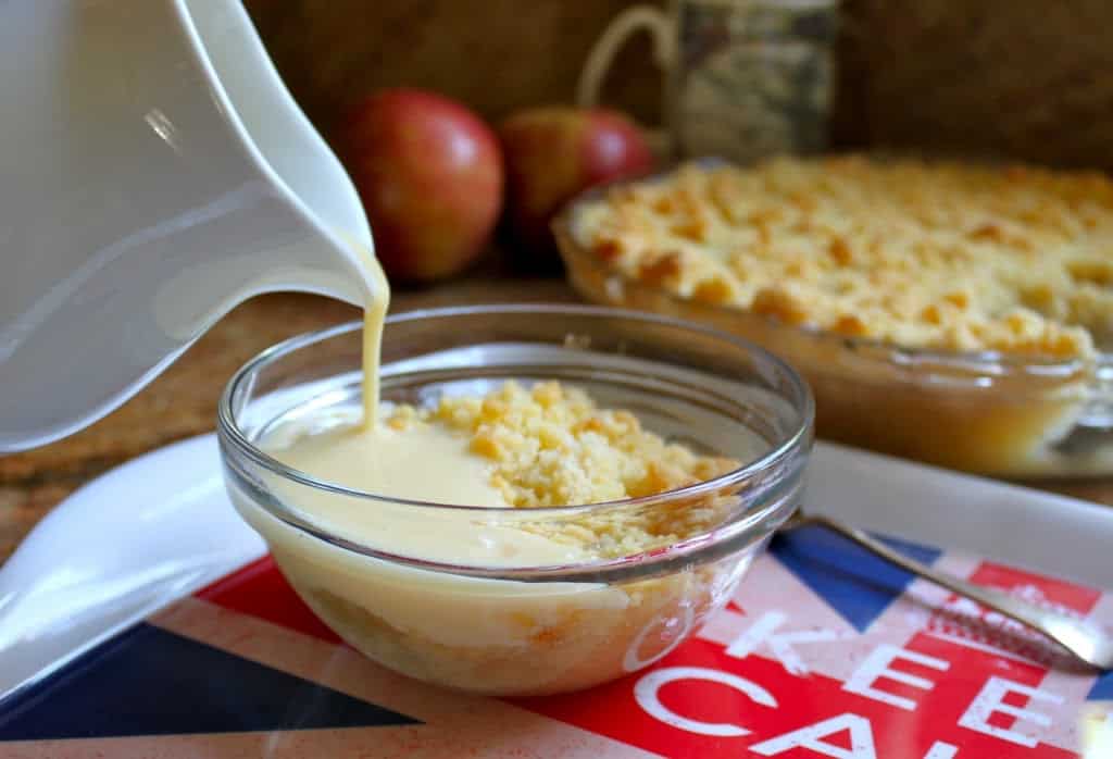 pouring homemade custard on apple crumble