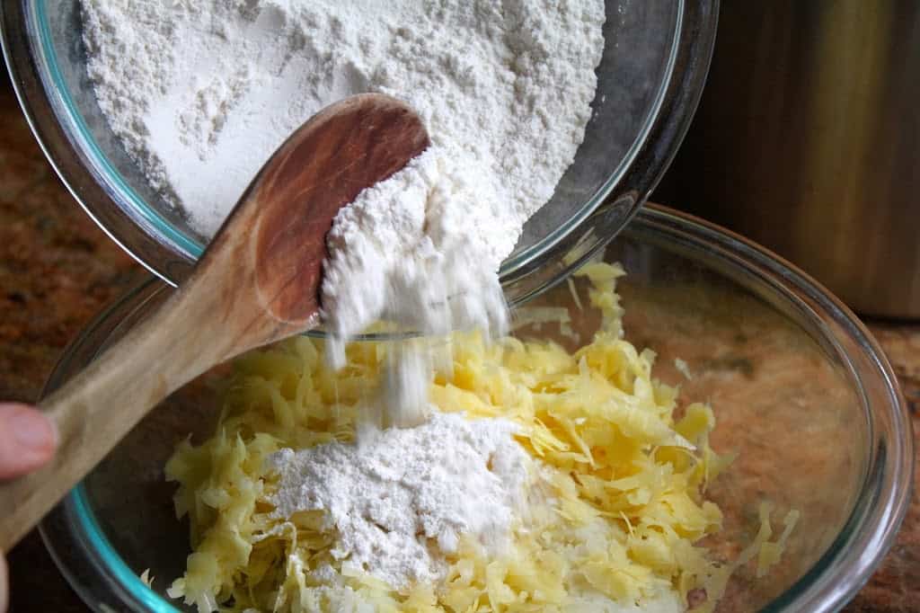 adding flour to ingredients in a bowl