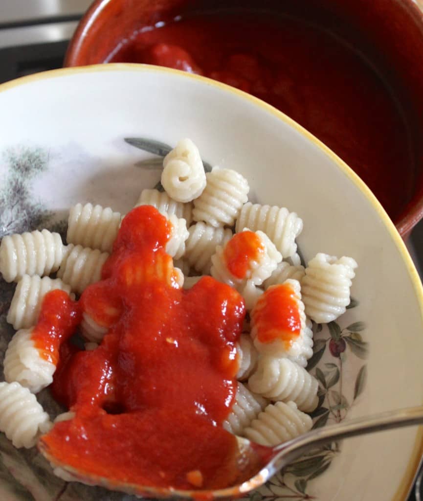 adding sauce to authentic Italian gnocchi