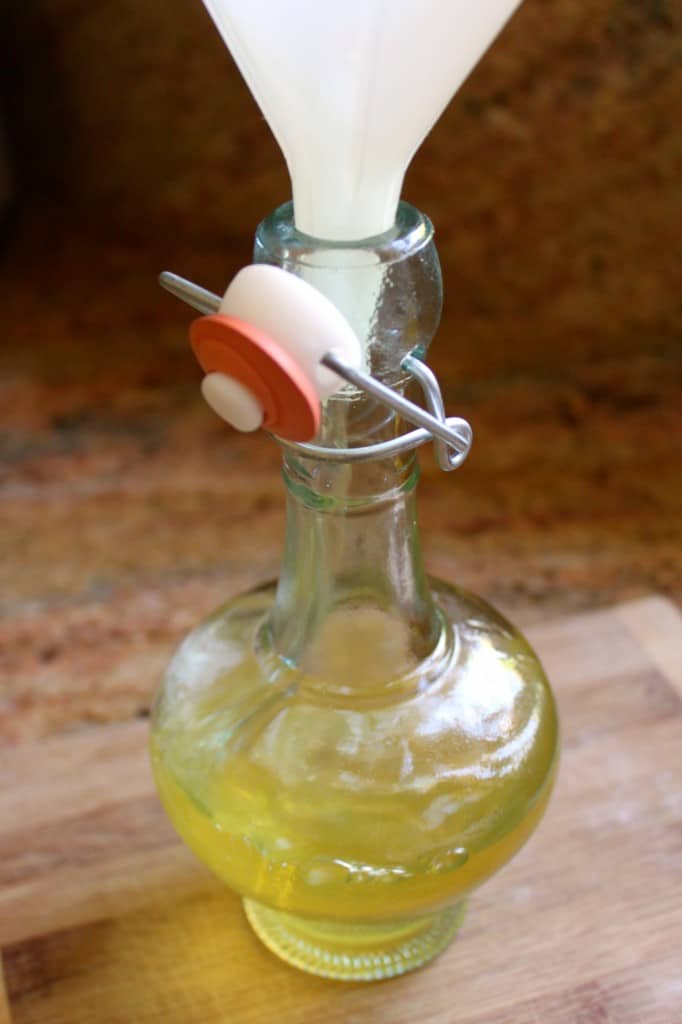 filling bottle with kumquat liqueur