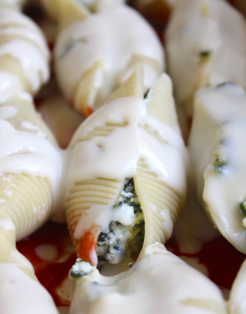stuffed shells with white sauce on top