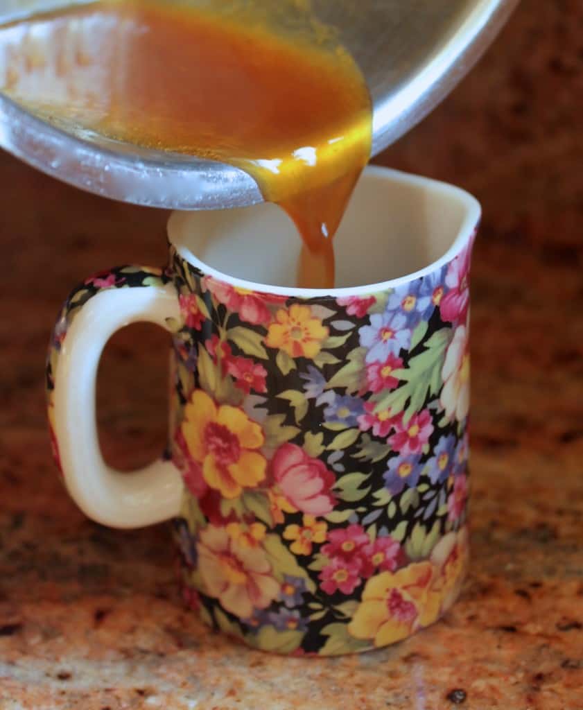pouring orange sauce into a jug