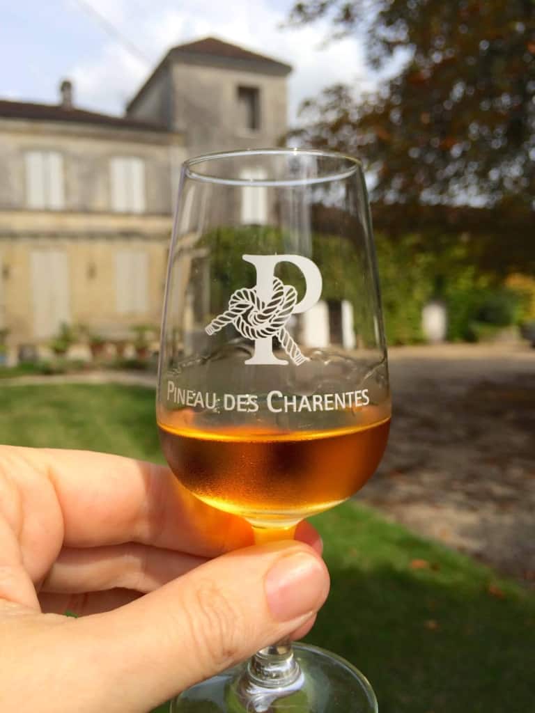 glass of pineau outside Chateau Guynot