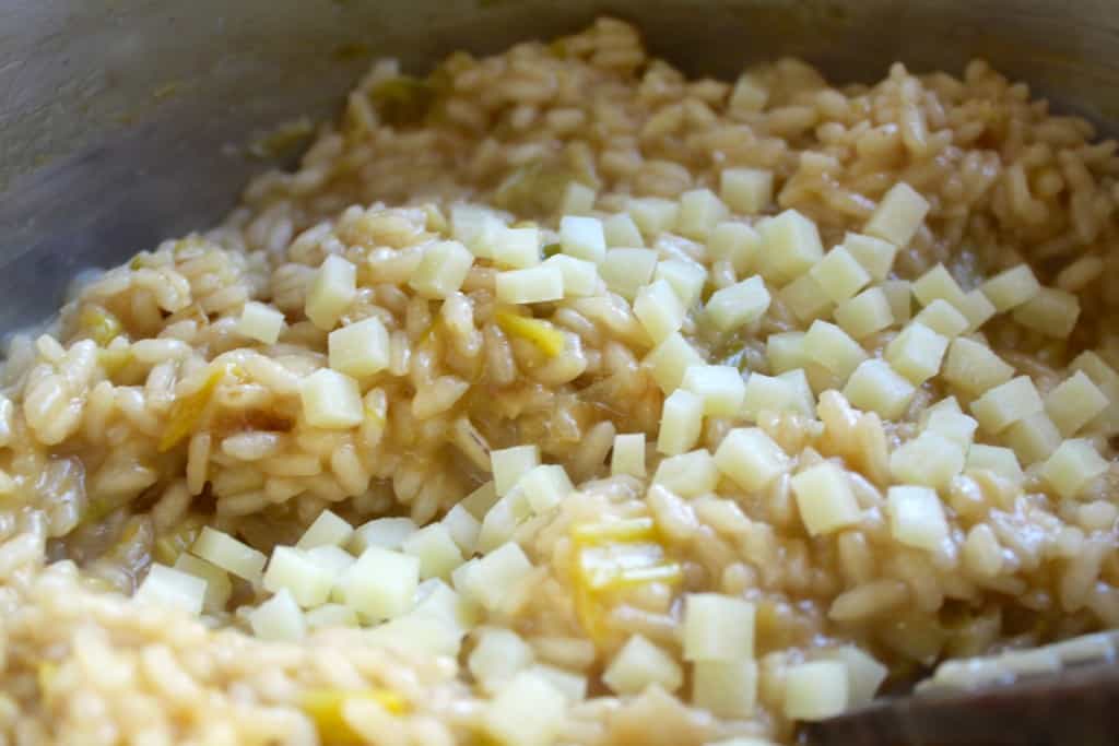 Adding the butter and cheeses at the end of making risotto.