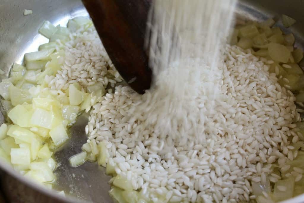 adding rice for risotto alla milanese recipe