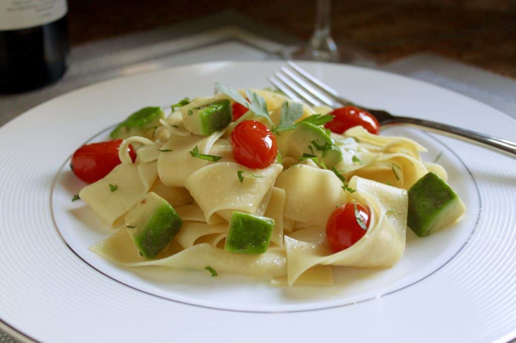 Egg pasta dish with avocado and tomatoes