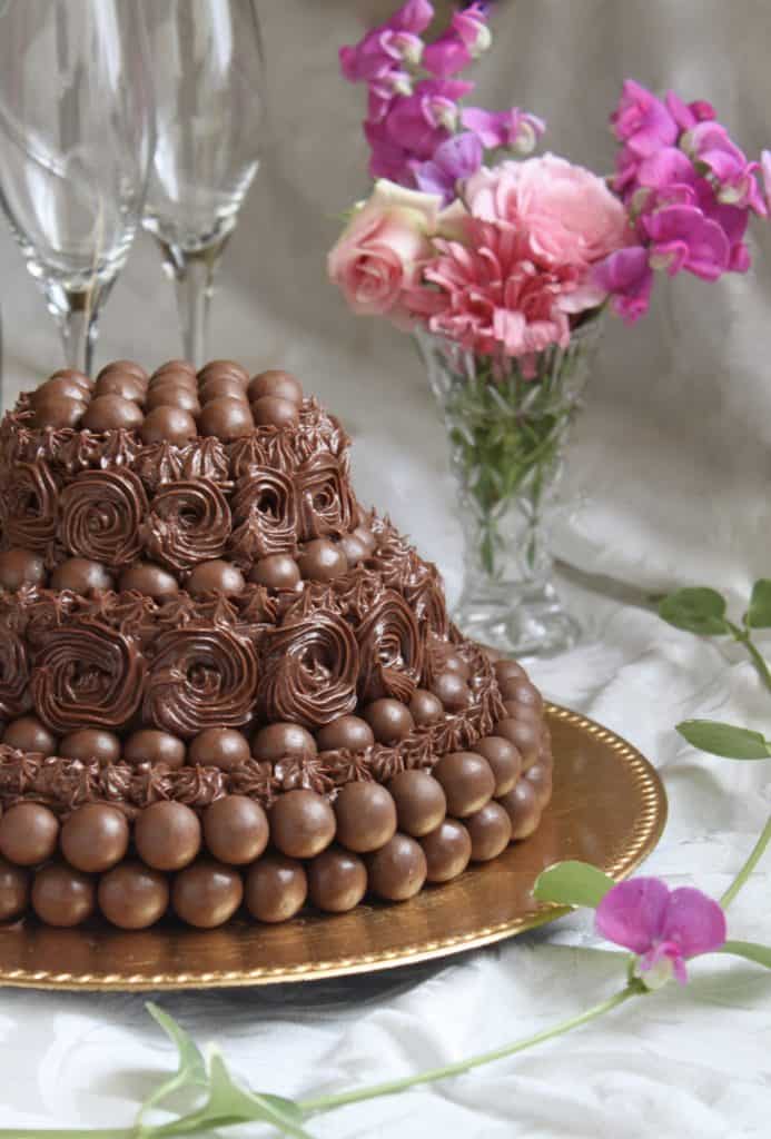 Malteser 3 tier cake with flowers in the background