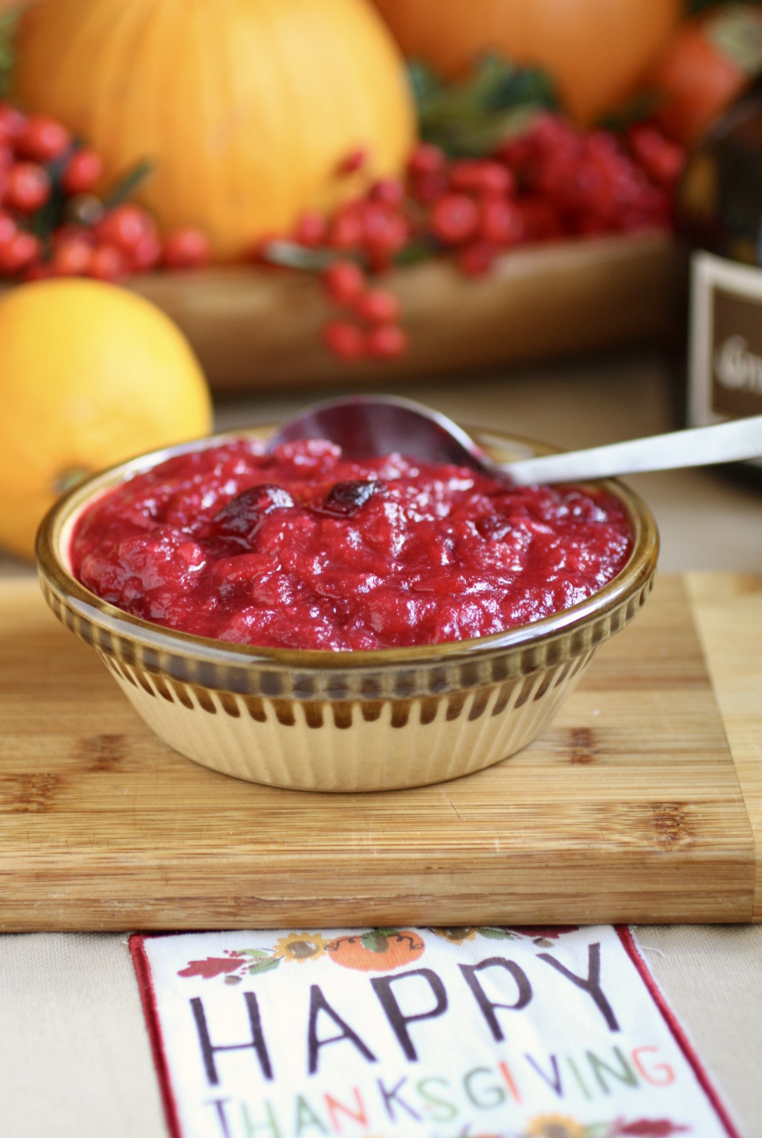 cranberry orange sauce with citrus in background and Happy Thanksgiving in foreground