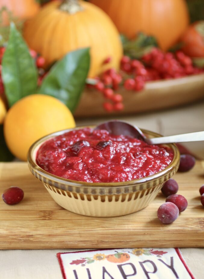 spoonful of cranberry orange sauce with citrus in background