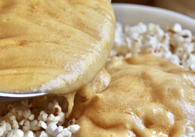 pouring caramel over popcorn