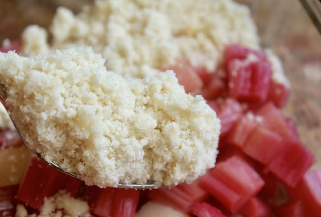 spooning crumble on the rhubarb