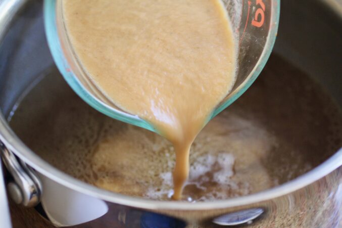 pouring blended veg into broth