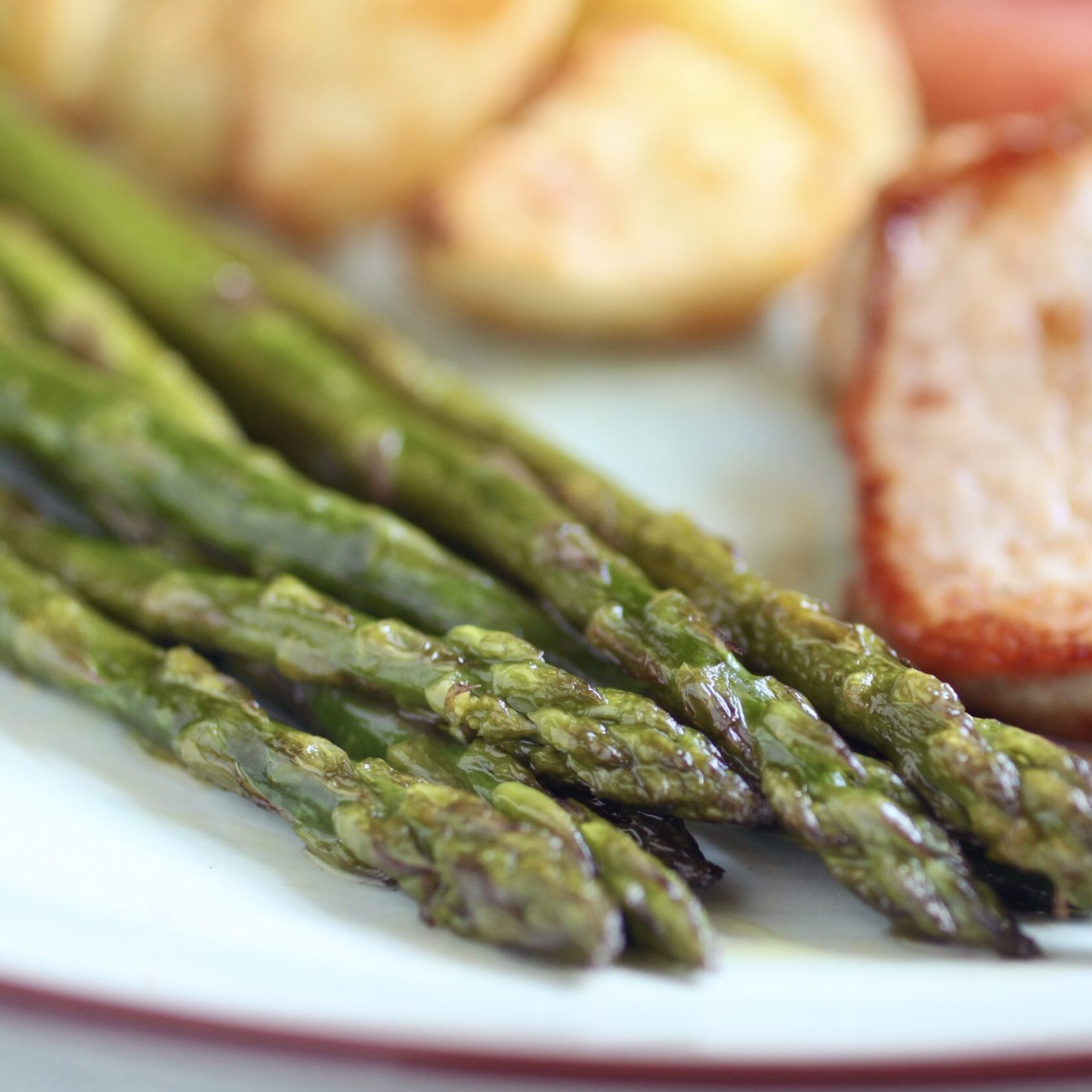 pan fried asparagus in foreground on plate