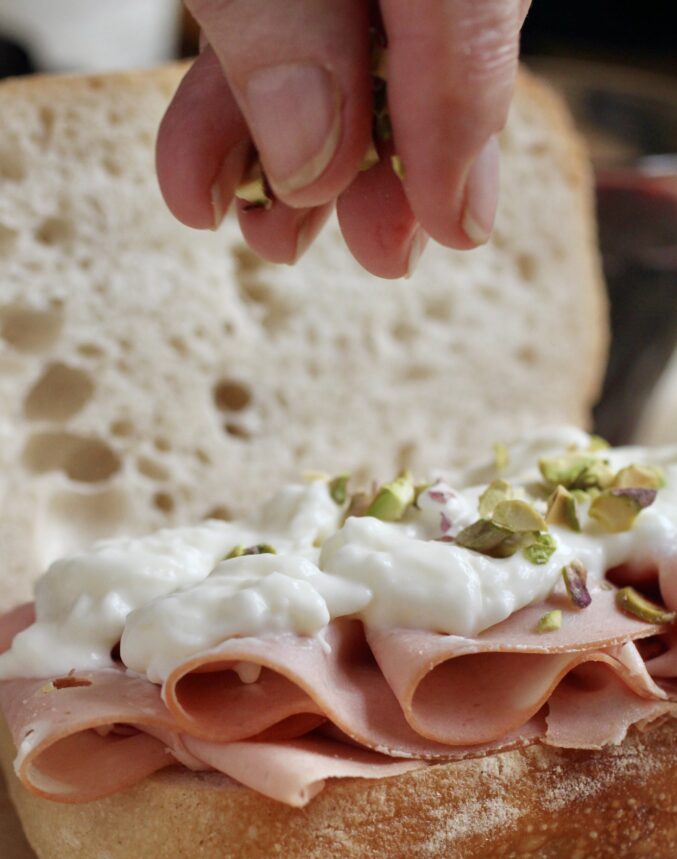 sprinkling pistachios on cheese