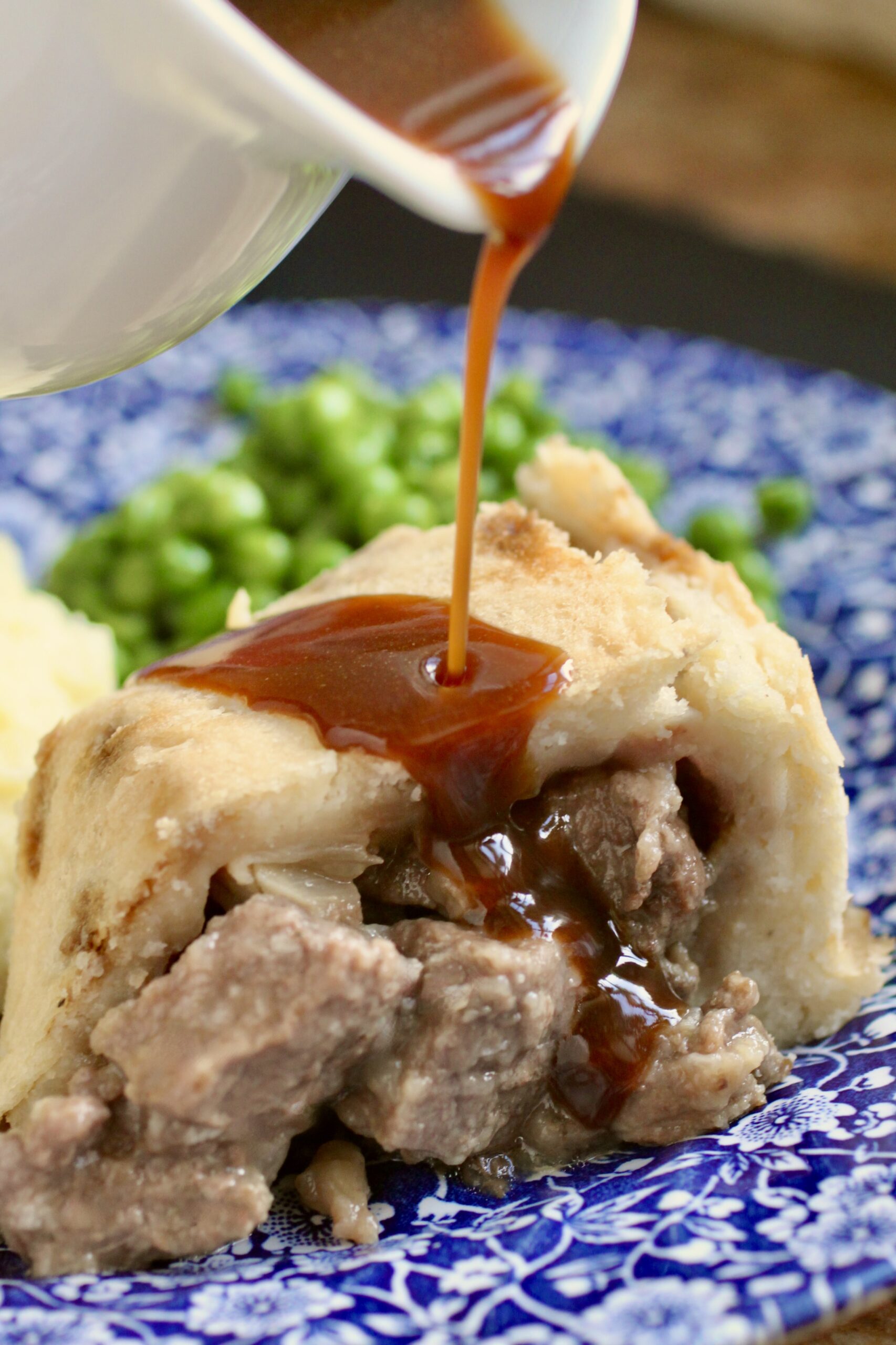 pouring gravy onto steak pudding